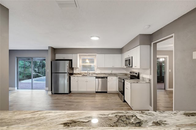 kitchen featuring white cabinetry, stainless steel appliances, and light hardwood / wood-style floors