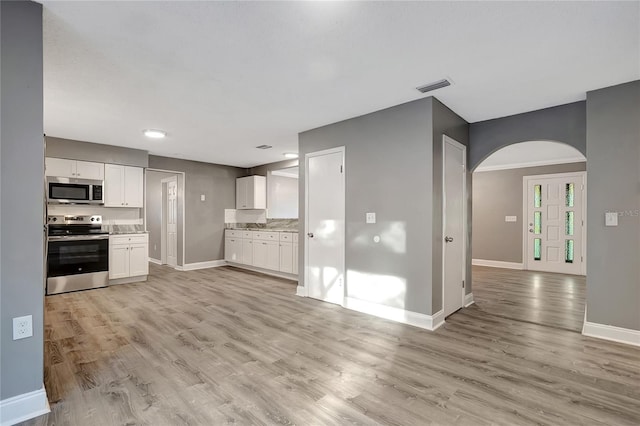 kitchen with white cabinetry, light hardwood / wood-style flooring, and stainless steel appliances