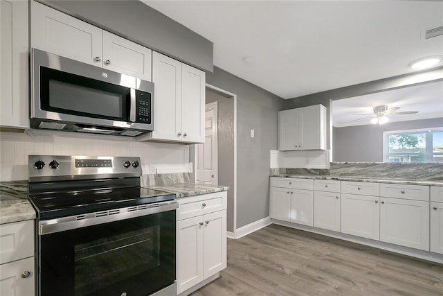 kitchen featuring white cabinets, appliances with stainless steel finishes, light hardwood / wood-style floors, and light stone counters