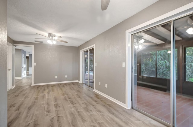 unfurnished room with a textured ceiling, light hardwood / wood-style flooring, and ceiling fan