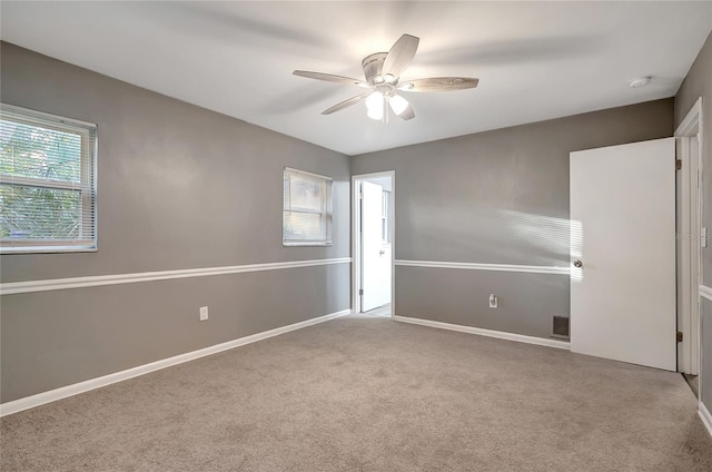 spare room featuring carpet, ceiling fan, and a healthy amount of sunlight