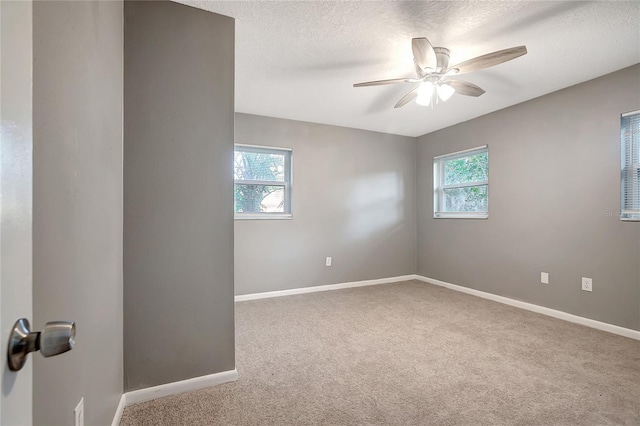 carpeted spare room with a textured ceiling and ceiling fan