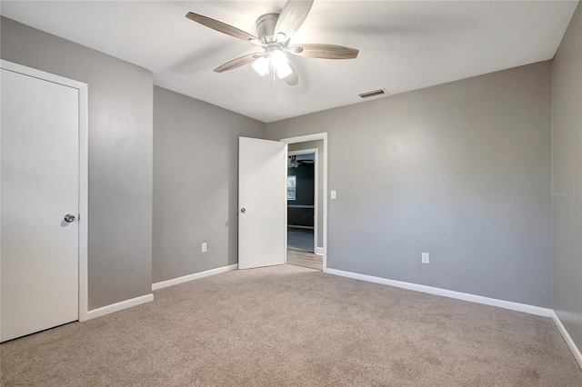 spare room featuring light colored carpet and ceiling fan