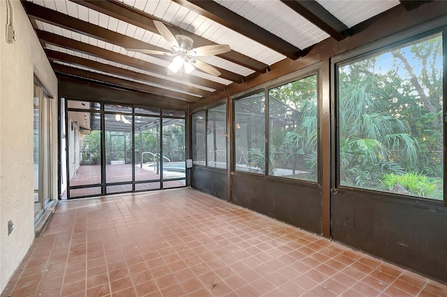 unfurnished sunroom featuring a wealth of natural light, beamed ceiling, and ceiling fan