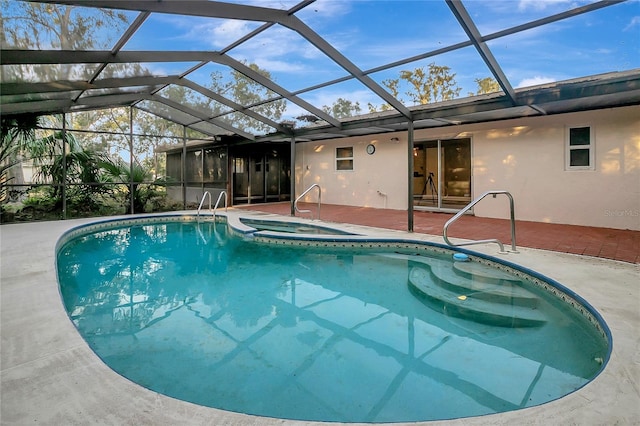 view of swimming pool with glass enclosure, an in ground hot tub, and a patio