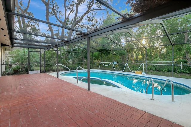 view of pool with glass enclosure and a patio