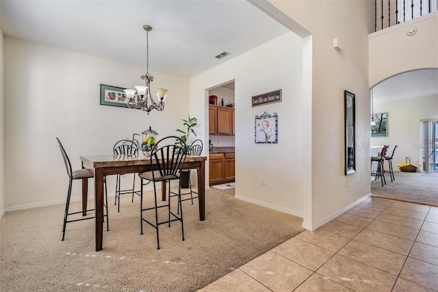 dining space with an inviting chandelier and light colored carpet