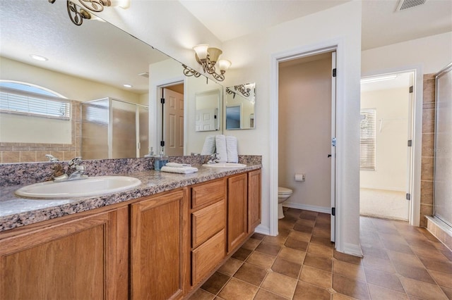 bathroom featuring vanity, a shower with shower door, toilet, and tile patterned flooring