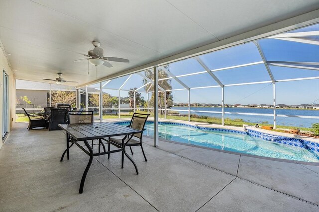 view of pool with a water view, ceiling fan, glass enclosure, and a patio