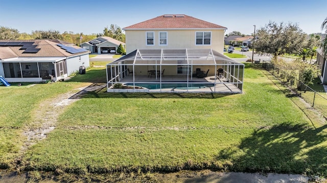 back of house with a patio, a lawn, and a lanai