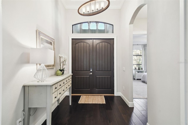 entrance foyer with dark hardwood / wood-style flooring, plenty of natural light, and ornamental molding