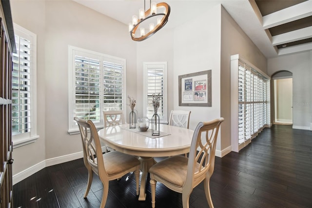 dining area with a notable chandelier, dark hardwood / wood-style floors, and beam ceiling