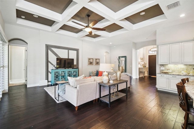 living room with ceiling fan, beamed ceiling, dark wood-type flooring, and coffered ceiling