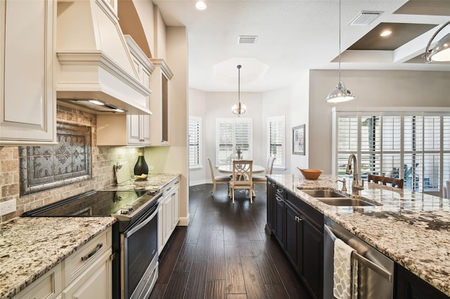 kitchen featuring sink, stainless steel appliances, hanging light fixtures, and dark wood-type flooring