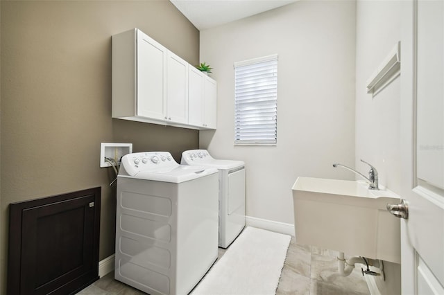 laundry area with washer and dryer, cabinets, and light tile patterned flooring