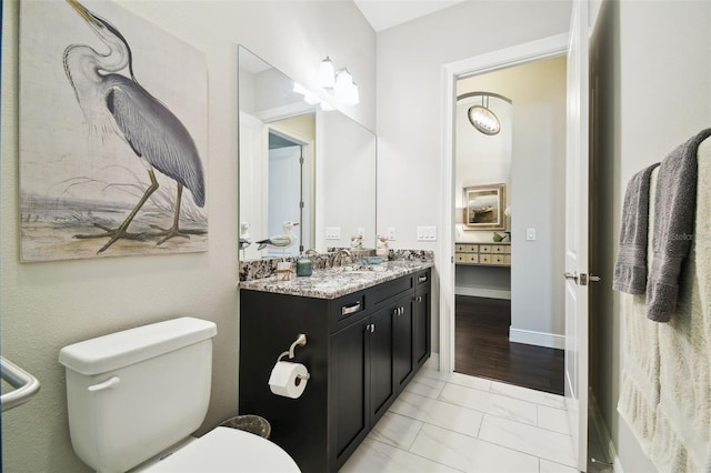 bathroom with hardwood / wood-style flooring, vanity, and toilet