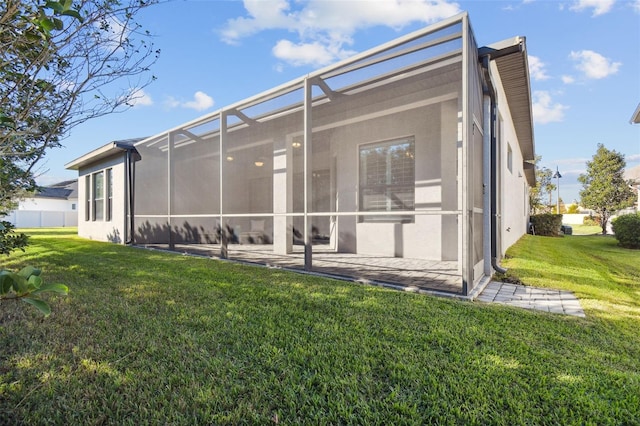 back of house with a lanai, a yard, and a patio