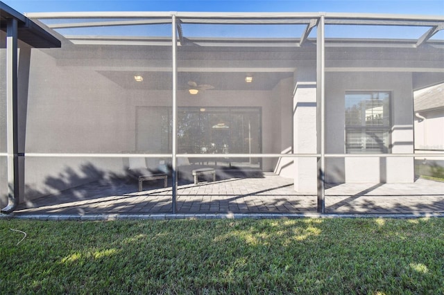 view of exterior entry with a yard and a patio