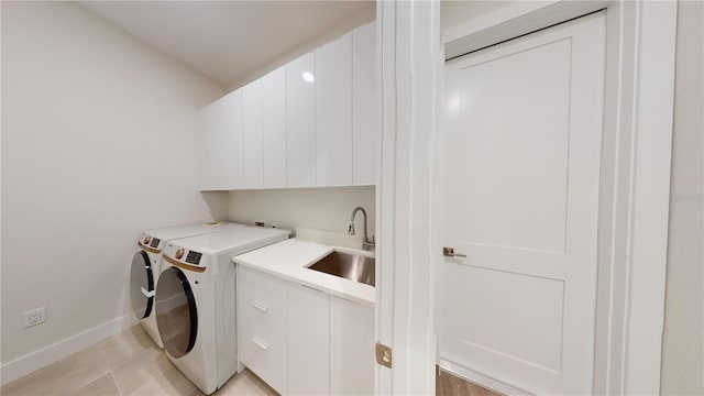 laundry area featuring sink, independent washer and dryer, and cabinets