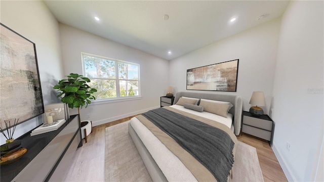 bedroom with a baseboard radiator and light wood-type flooring