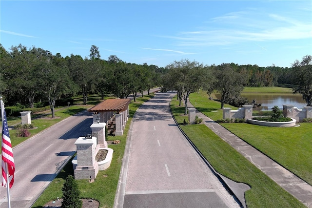 view of community featuring a water view and a lawn