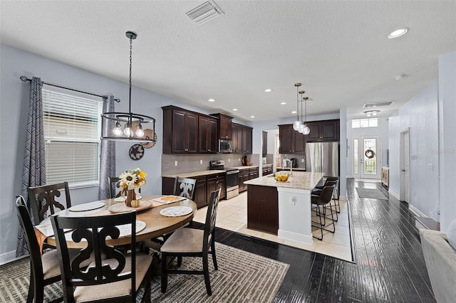 dining area featuring a textured ceiling and light hardwood / wood-style floors