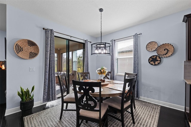 dining area featuring an inviting chandelier, dark hardwood / wood-style floors, and a textured ceiling