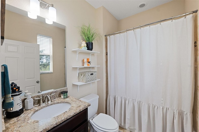 bathroom featuring toilet, curtained shower, and vanity