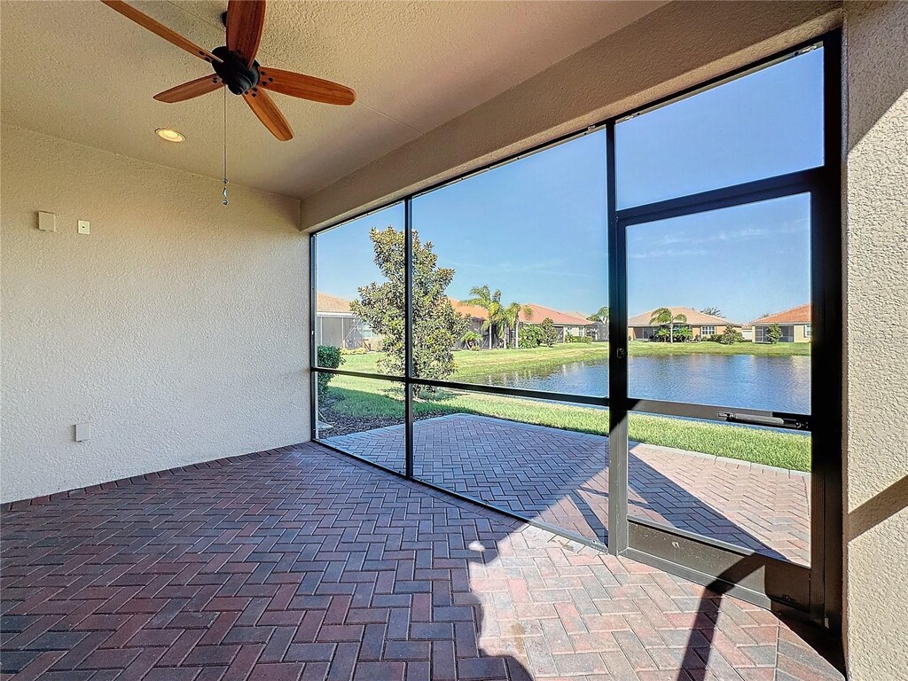unfurnished sunroom featuring a water view and a residential view