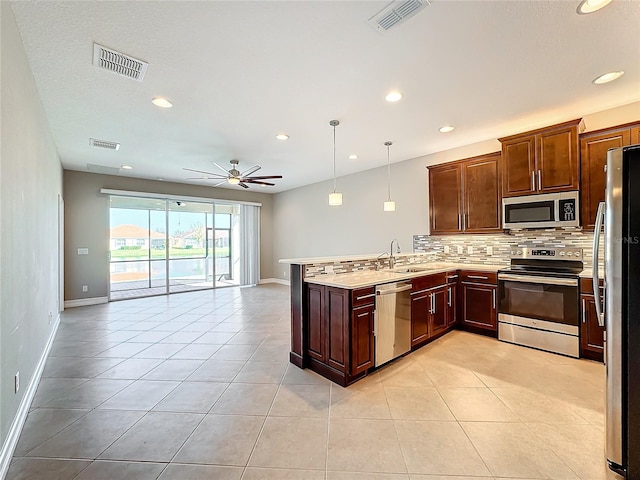 kitchen featuring ceiling fan, stainless steel appliances, kitchen peninsula, pendant lighting, and light tile patterned floors