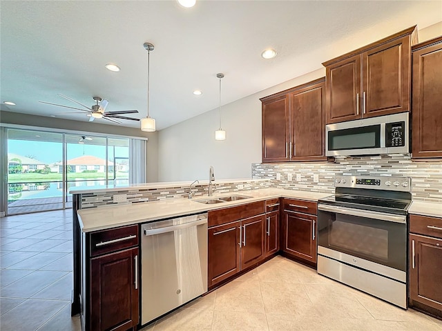 kitchen with decorative backsplash, sink, stainless steel appliances, and hanging light fixtures