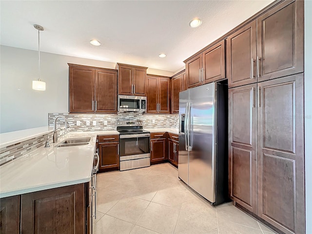 kitchen featuring sink, stainless steel appliances, tasteful backsplash, pendant lighting, and light tile patterned floors