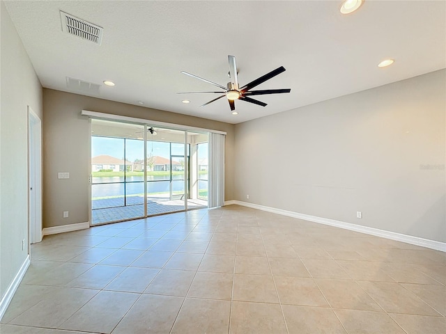 tiled empty room featuring ceiling fan