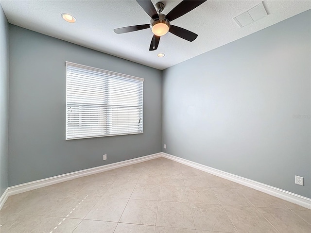 empty room with light tile patterned floors, a textured ceiling, and ceiling fan