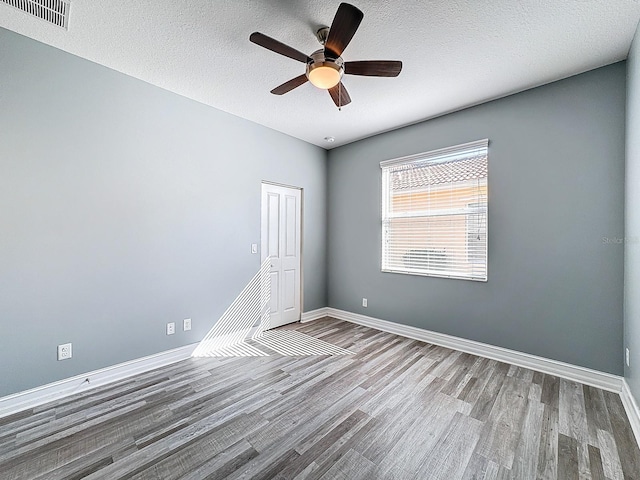 unfurnished room with ceiling fan, a textured ceiling, and hardwood / wood-style flooring