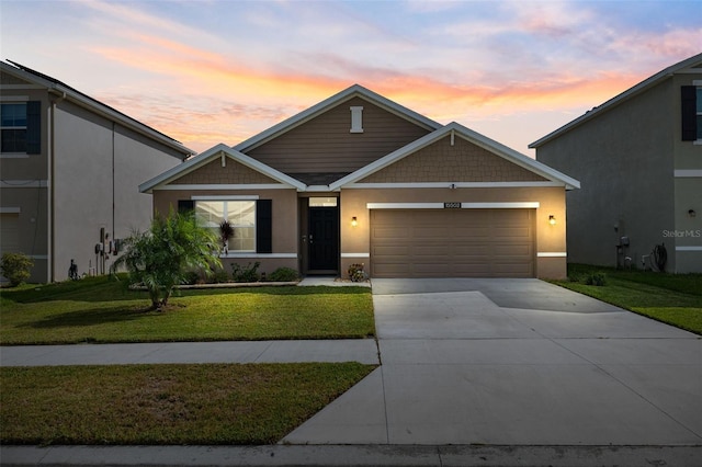 view of front of property with a garage and a yard