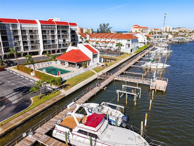 view of dock with a water view and a community pool