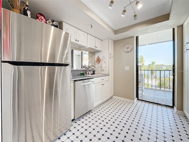 kitchen featuring white cabinetry, appliances with stainless steel finishes, a tray ceiling, and sink