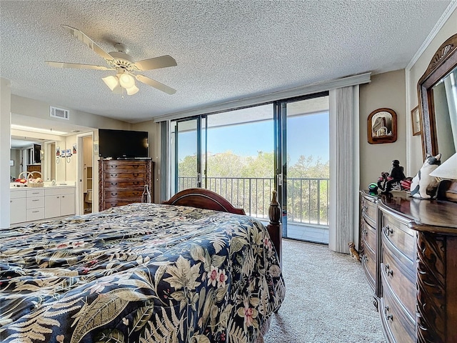 carpeted bedroom featuring a textured ceiling, access to exterior, a wall of windows, and ensuite bath