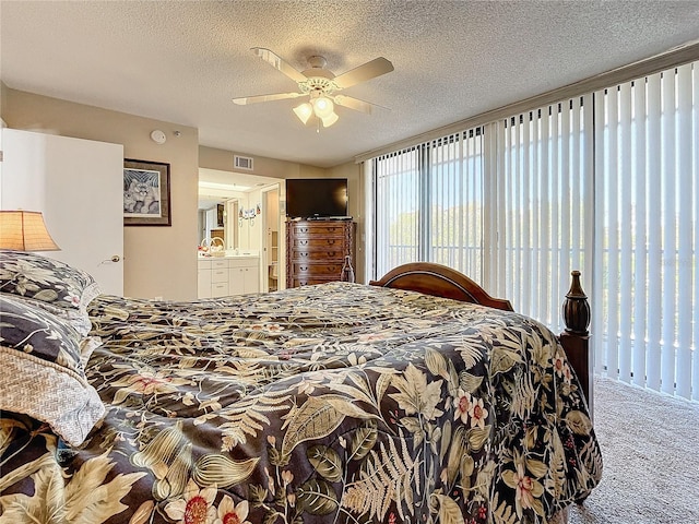 carpeted bedroom featuring ceiling fan, connected bathroom, and a textured ceiling