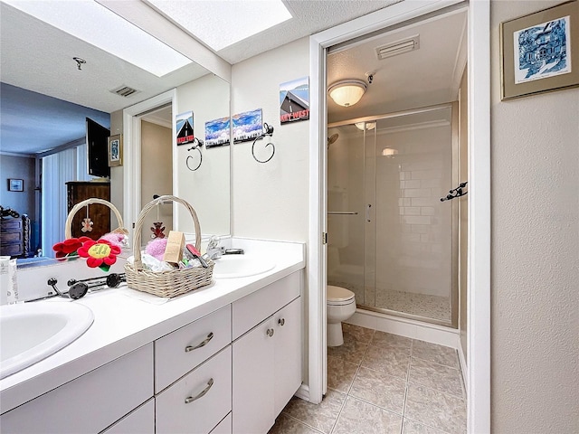 bathroom featuring a shower with shower door, vanity, toilet, tile patterned floors, and a textured ceiling