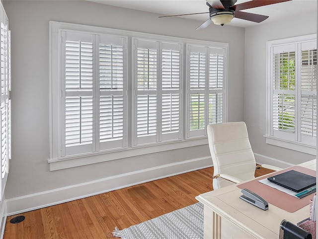 office space featuring a ceiling fan, baseboards, and wood finished floors