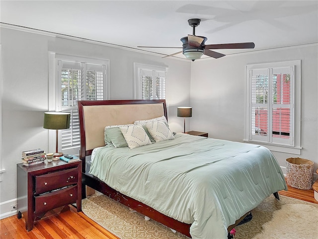 bedroom featuring a ceiling fan, light wood-type flooring, and baseboards