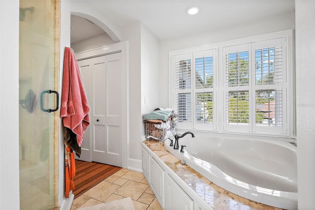 bathroom featuring recessed lighting, a closet, a shower stall, a bath, and tile patterned floors