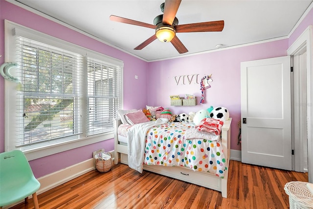 bedroom featuring ornamental molding, wood finished floors, a ceiling fan, and baseboards