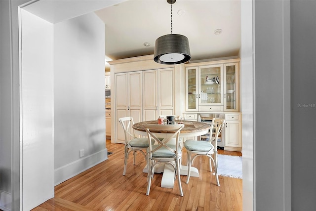 dining area featuring light wood finished floors and baseboards