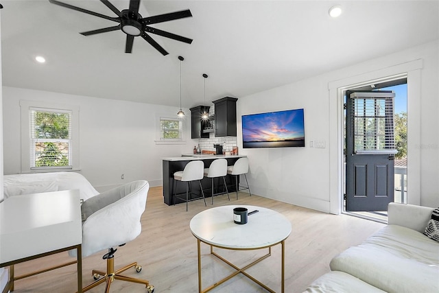 living room featuring light wood-style floors, lofted ceiling, and baseboards