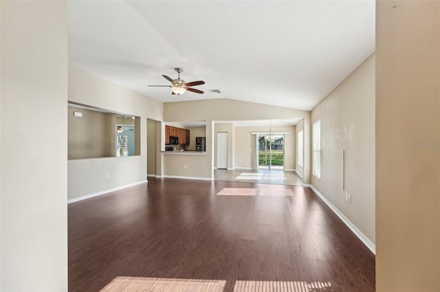 unfurnished living room featuring vaulted ceiling, wood-type flooring, and ceiling fan with notable chandelier