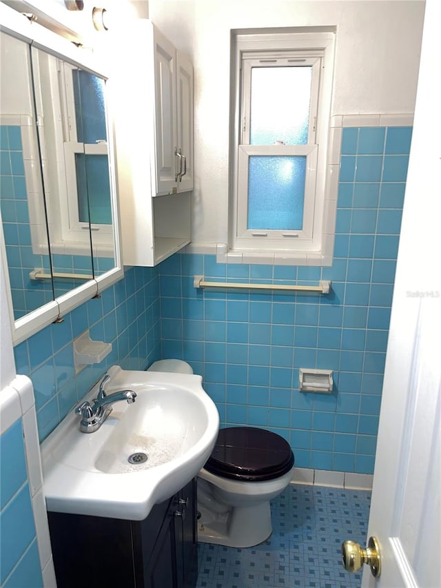 bathroom featuring tile walls, vanity, toilet, and tile patterned flooring