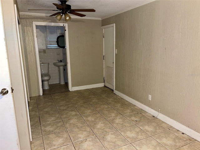 interior space featuring sink, crown molding, light tile patterned floors, ensuite bathroom, and ceiling fan